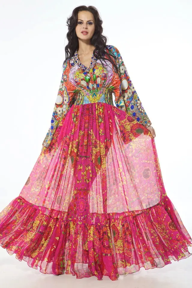 Model wearing a silk kimono-sleeve kaftan in pink pebble and tile print, with Swarovski hand embroidery on the neckline and back, and gathered gypsy-style layers.